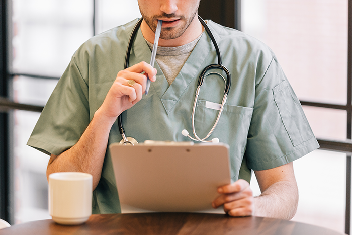 The Erectimus Medical Disclaimer page footer image of doctor looking at clipboard