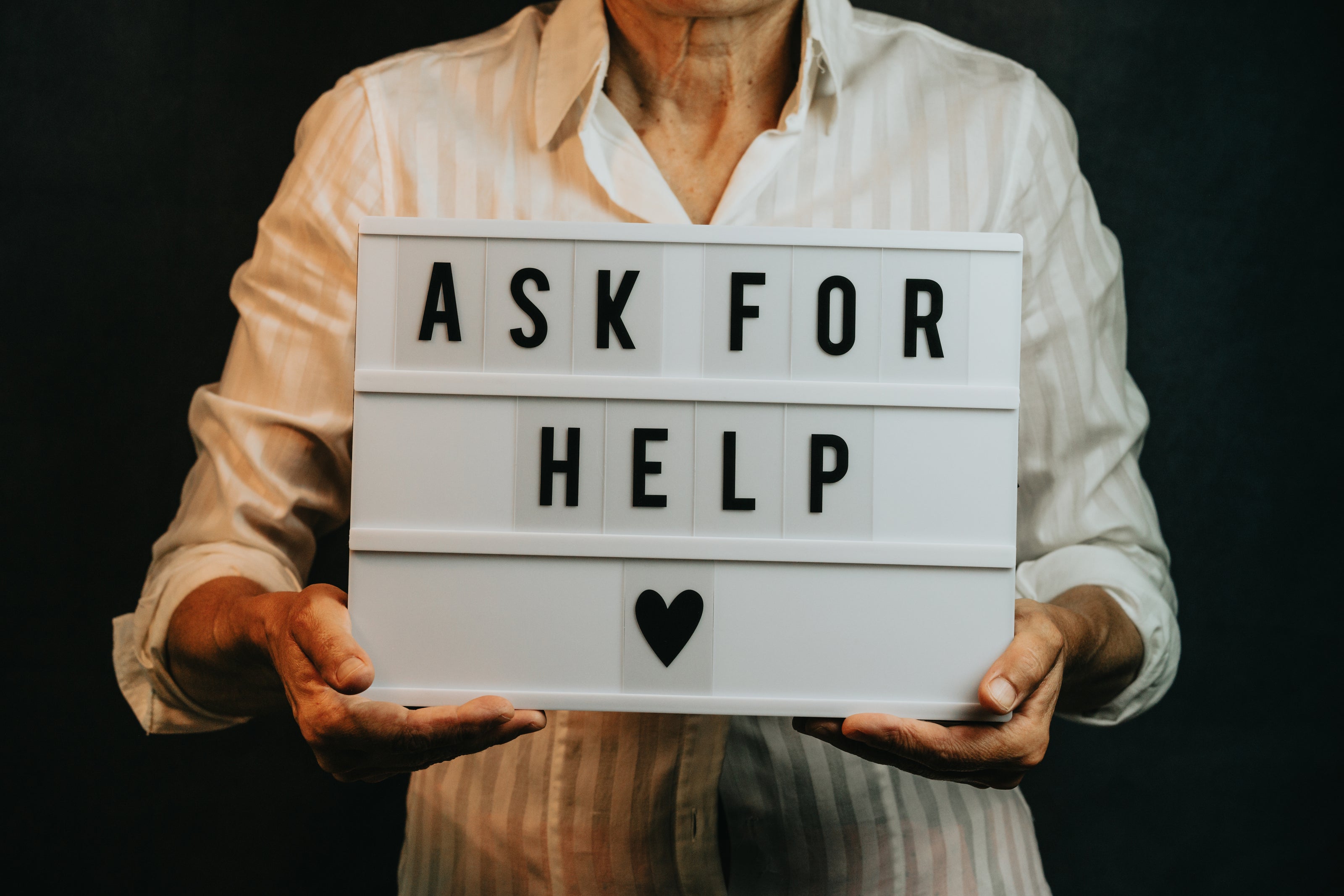 An old man holding an sk for Help sign