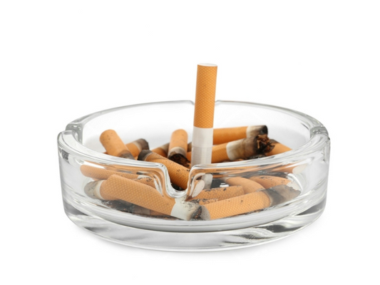 Ashtray full of cigarette butts illustrating smoking as a risk factor for erectile dysfunction