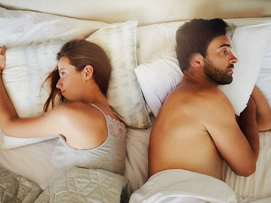 Frustrated couple lying back to back in bed | Erectimus