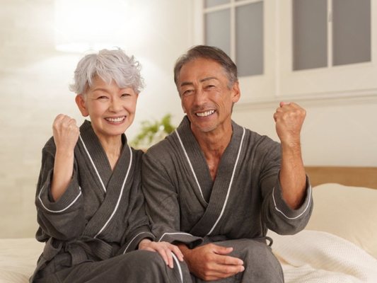 Older couple relaxing together in bathrobes, representing how to help a partner last longer in bed