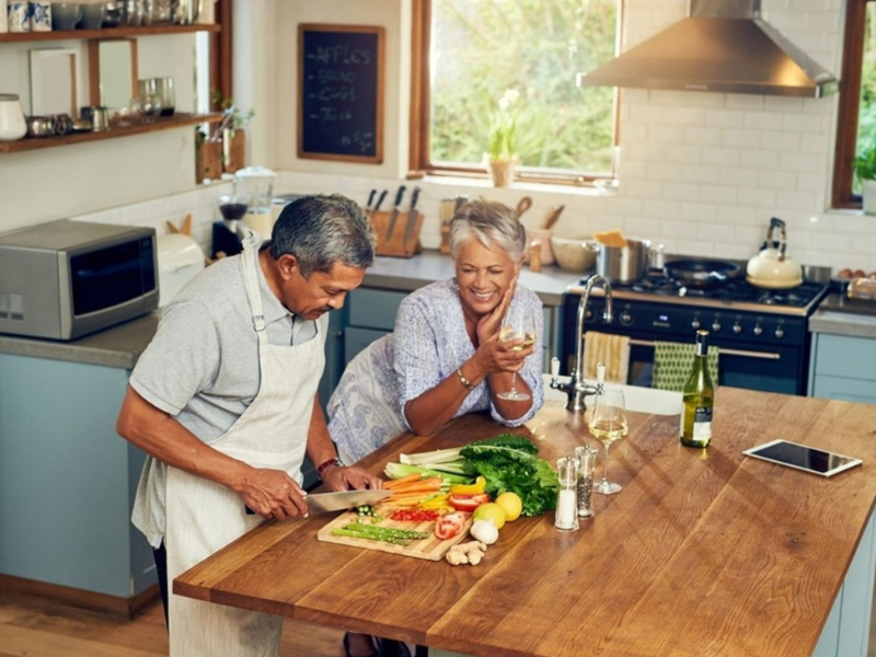 Mature couple preparing fresh vegetables together in a kitchen representing healthy lifestyle and natural support for male sexual health