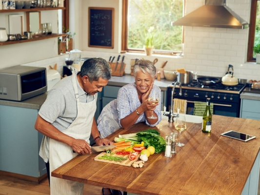 Mature couple preparing fresh vegetables together in a kitchen representing healthy lifestyle and natural support for male sexual health